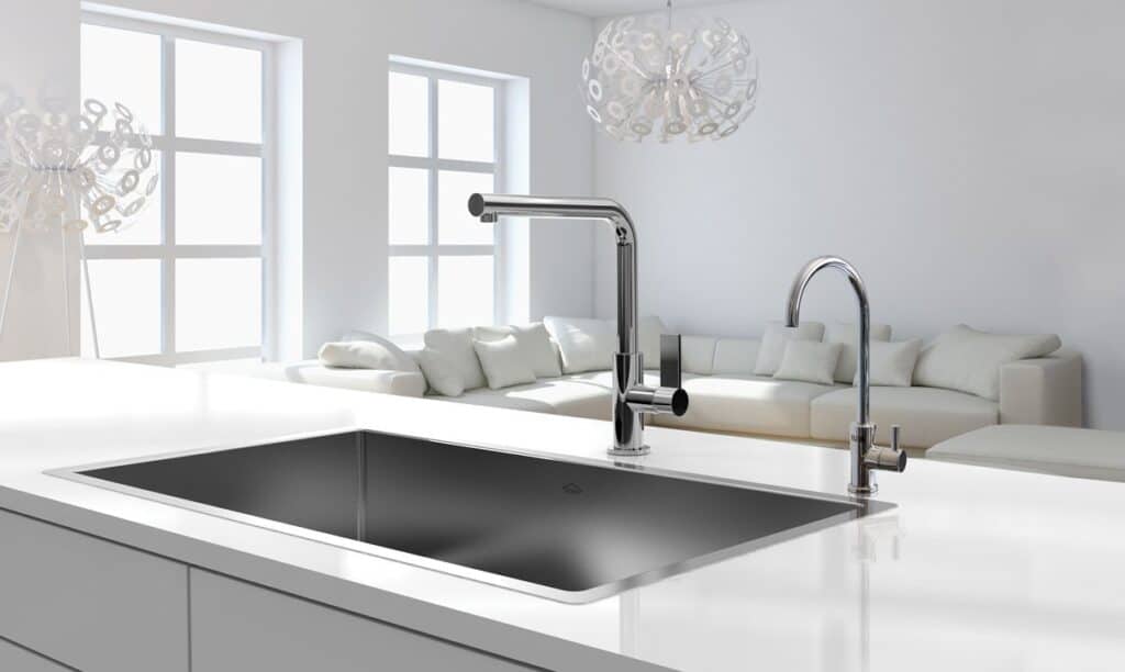 Improve Water Quality in your New Apartment 2 A modern kitchen sink with a sleek faucet is set within a glossy white countertop in this new apartment. There is a minimalist living area with white furniture and large windows in the background, creating an inviting space. The advanced filtration system improves water quality for healthier living.