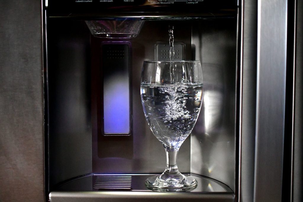 Water supply to fridge 2 A water dispenser fills a large glass with water directly from the water supply to the fridge.